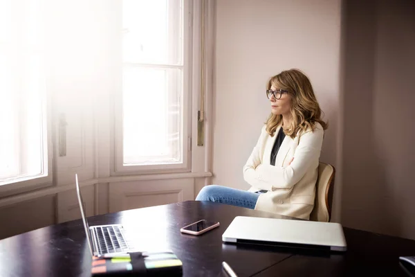 Retrato Mujer Negocios Elegante Mirando Pensativamente Mientras Sienta Escritorio Junto —  Fotos de Stock