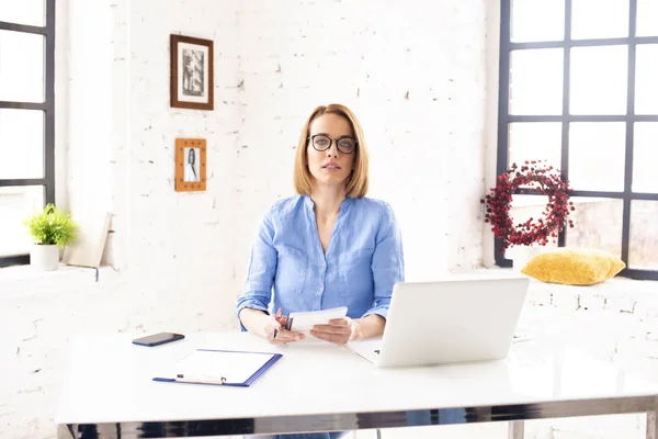 Zdjęcie Atrakcyjnej Dojrzałej Bizneswoman Siedzącej Biurkiem Notatnikiem Wykonującej Papierkową Robotę — Zdjęcie stockowe