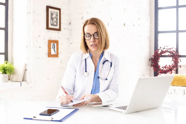 Girato Mezza Età Medico Donna Facendo Alcune Scartoffie Mentre Seduto — Foto Stock