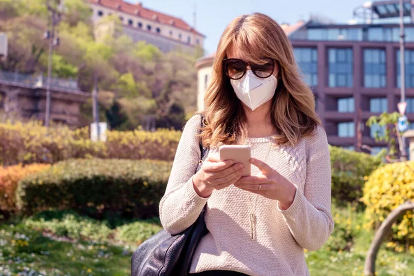 中年妇女戴着呼吸口罩在大肠病毒爆发期间进行健康保护时被枪击身亡 自信的女人站在街上发短信 — 图库照片
