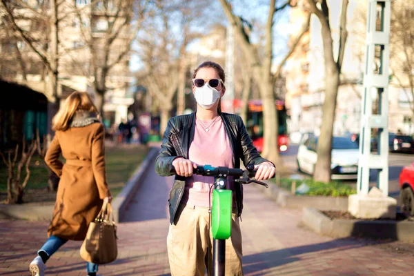 Tiro Mujer Joven Con Máscara Facial Mientras Monta Scooter Eléctrico — Foto de Stock