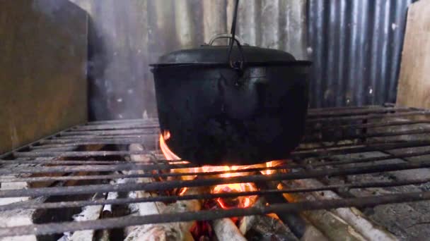 Zpomalený pohyb černého hrnce na vaření, kotle, na otevřeném venkovním ohni. — Stock video