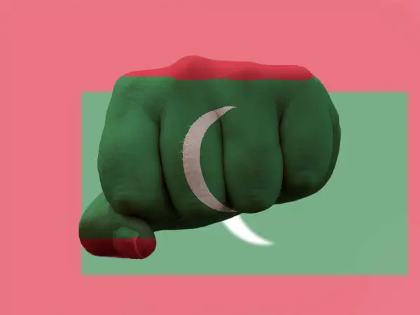 권력을 상징하는 인간의 주먹에 그려져 있는 깃발에 그려진 몰디브 — 스톡 사진