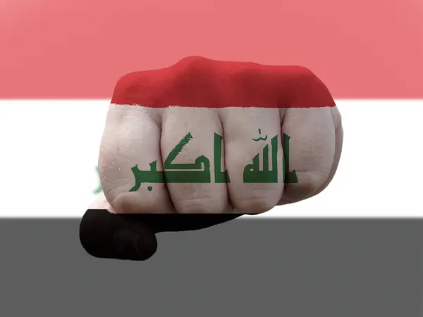 Прапор Іраку зображений на людському кулаку, що представляє владу. — стокове фото