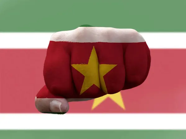 Suriname Flagge auf menschliche Faust gemalt, die Macht symbolisiert — Stockfoto