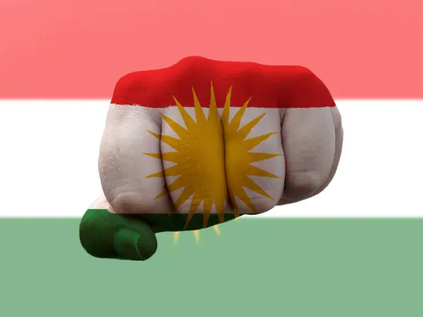 Прапор Курдистану зображений на людському кулаку, що представляє владу. — стокове фото