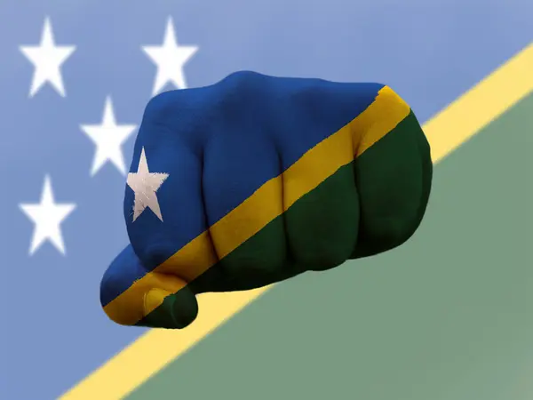 Прапор Соломонових островів, намальований на кулаку людини, що представляє владу. — стокове фото