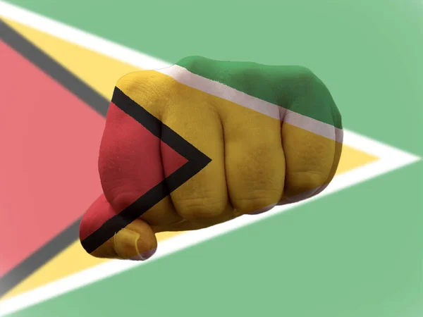 Guyana Bayrağı insan yumruğunun üzerine boyanmış. Gücü temsil ediyor. — Stok fotoğraf