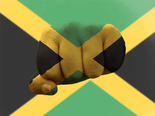 Jamaica Vlag geschilderd op menselijke vuist die macht vertegenwoordigt — Stockfoto