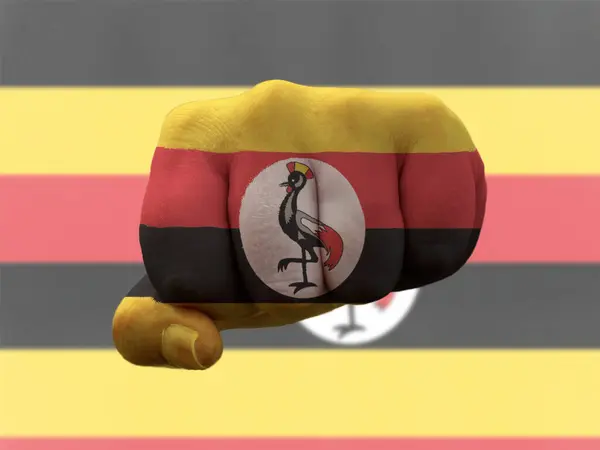 Uganda-Flagge auf Menschenfaust gemalt, die Macht symbolisiert — Stockfoto