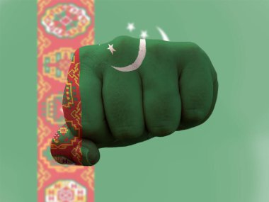 İnsan yumruğunun üzerine boyanmış Türkmenistan Bayrağı gücü temsil ediyor