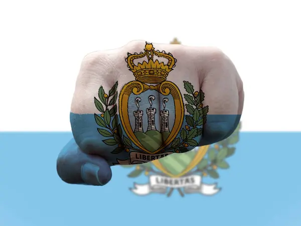 San Marino bayrağı insan yumruğuna boyanmış. Gücü temsil ediyor. — Stok fotoğraf