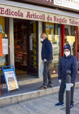 Pietrasanta, Lucca: le persone eseguono le attivit quotidiane protetti da guanti e mascherine