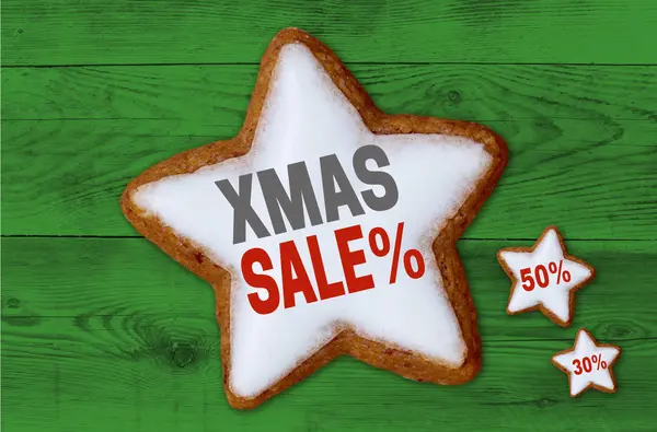 XMAS Sale cinnamon star on green wood background — Stock Photo, Image