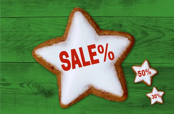 Sale cinnamon star on green wood background — Stock Photo, Image