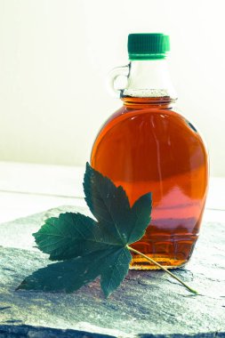 Maple syrup in a bottle with maple leaf clipart