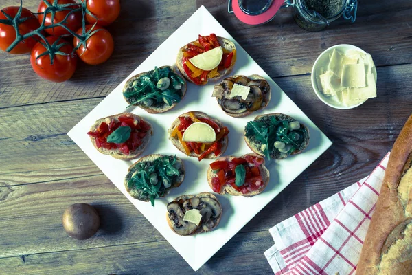 Bruschetta with beans and arugula, mushrooms, goat cheese — Stock Photo, Image