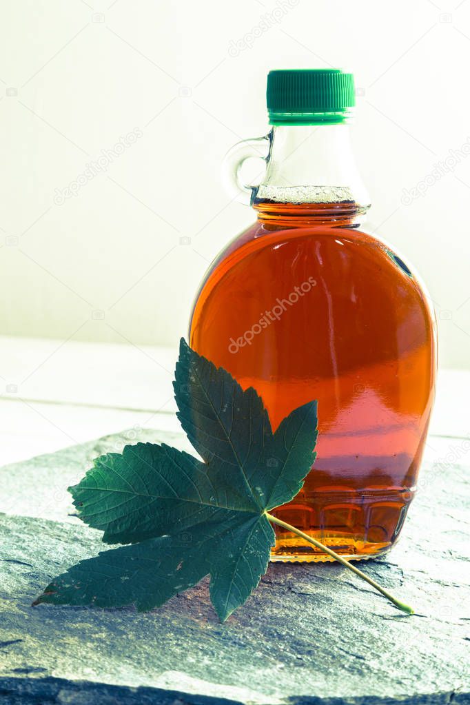 Maple syrup in a bottle with maple leaf