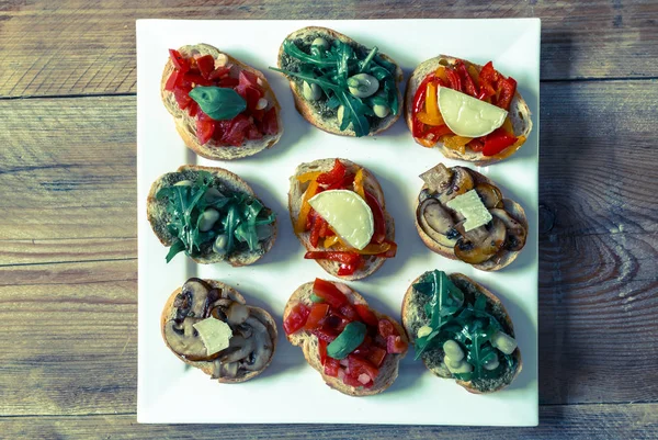 Bruschetta with beans and arugula, mushrooms, goat cheese — Stock Photo, Image