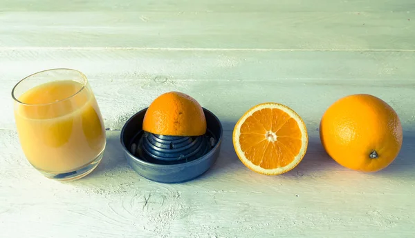 Presse-agrumes pour jus d'orange et orange sur table en bois — Photo