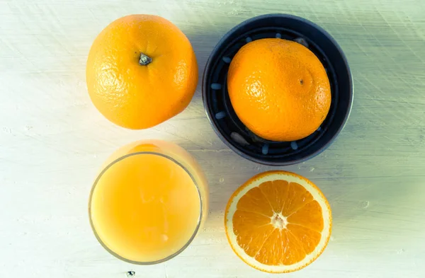 Presse-agrumes pour jus d'orange et orange sur table en bois — Photo