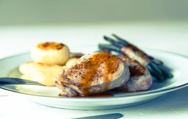 Varkensvlees medaillons met aardappelen en bonen — Stockfoto