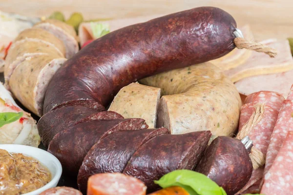 Sausage plate variation on a wooden table — Stock Photo, Image