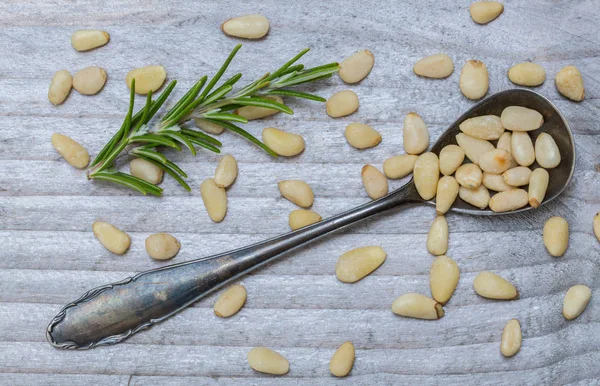 Pinjenötter och rosmarin på en sked makro — Stockfoto