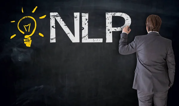 Businessman writes NLP on blackboard concept — Stock Photo, Image