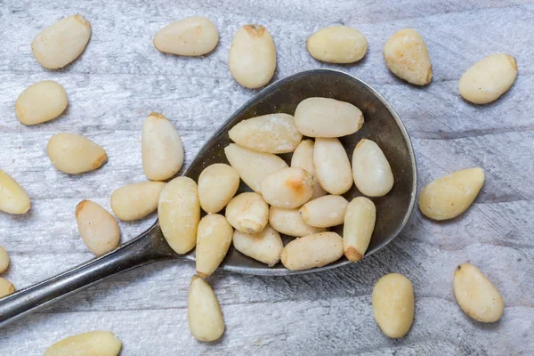 Сосновые орехи на ложечном макро — стоковое фото