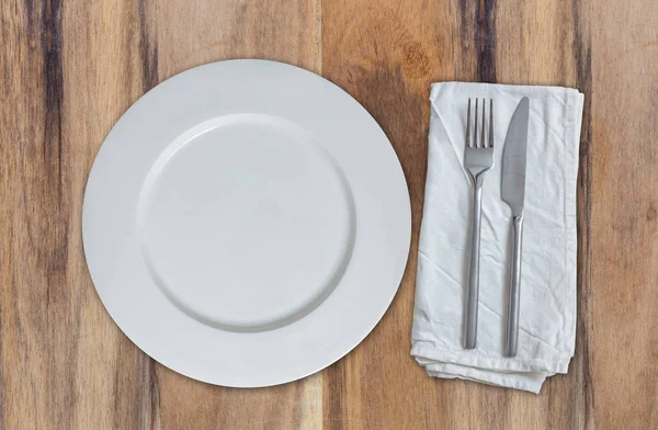 Empty plate with cutlery on acacia wood top view — Stock Photo, Image