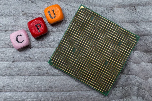 CPU letter cube and processor on gray wood visualization — Stock Photo, Image