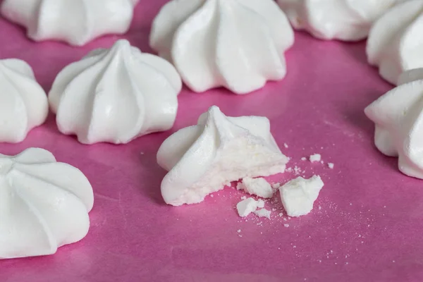 Many meringues on pink paper top view — Stock Photo, Image