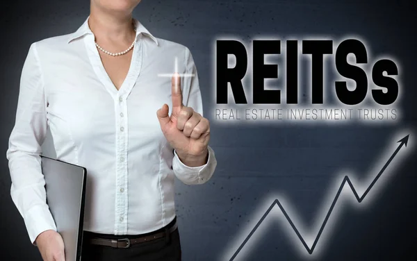 REITs pekskärm visas av affärskvinna — Stockfoto