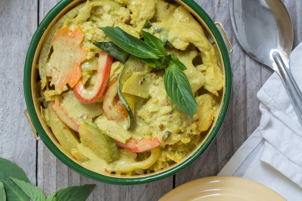 Ahşap masa üzerinde bir kasede sarı Tay köri