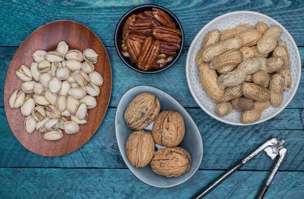 Jordnötter pistaschmandel valnötter och pekannötter på bensin trä — Stockfoto