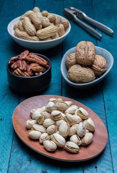 Jordnötter pistaschmandel valnötter och pekannötter på bensin trä — Stockfoto