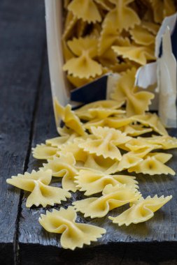 Farfalle şehriye koyu renkli rustik ahşap üzerinde