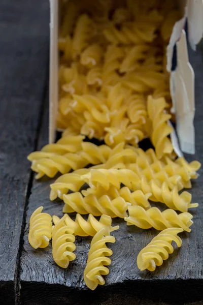 Fideos Fusilli sobre madera rústica oscura — Foto de Stock