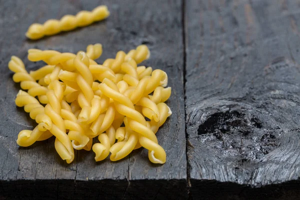 Gemelli noodle on dark rustic wood — Stock Photo, Image