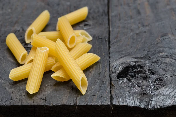 Tortiglioni fideos sobre madera rústica oscura — Foto de Stock