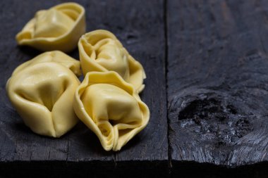 Koyu renkli rustik ahşap üzerinde tortellini makarna