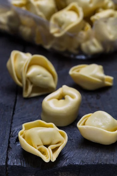 Koyu renkli rustik ahşap üzerinde tortellini makarna
