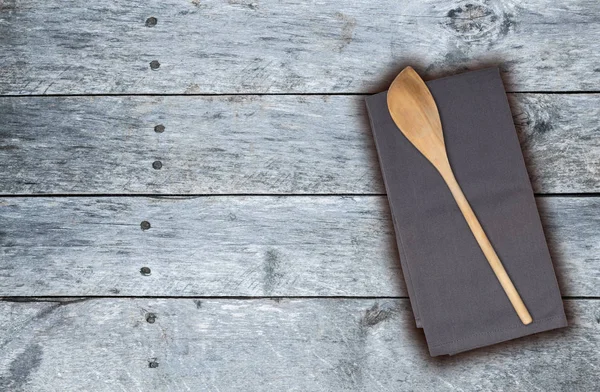 Cuchara de madera y toalla de cocina en madera vintage gris — Foto de Stock