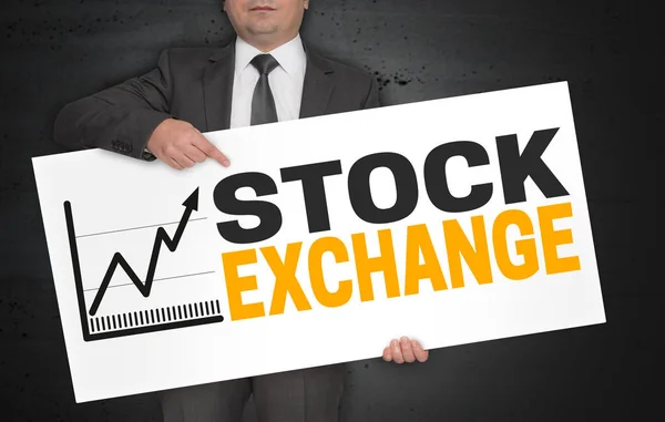 Cartaz da bolsa de valores é realizada pelo empresário — Fotografia de Stock