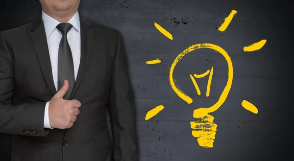 電球のコンセプトと親指を持ったビジネスマン — ストック写真