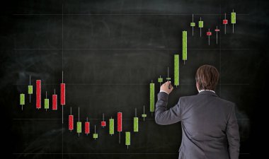Businessman paints with chalk chart on blackboard.