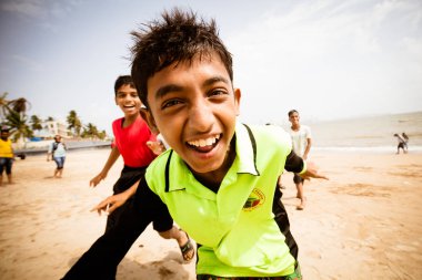 Hintli çocuk kumsalda oynarken