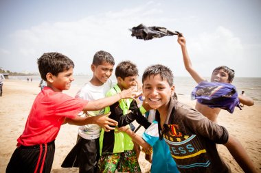 Hintli çocuk kumsalda oynarken