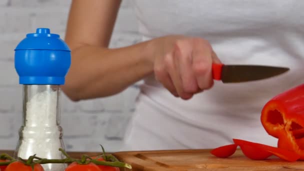 Chica corte pimentón rojo para ensalada — Vídeos de Stock
